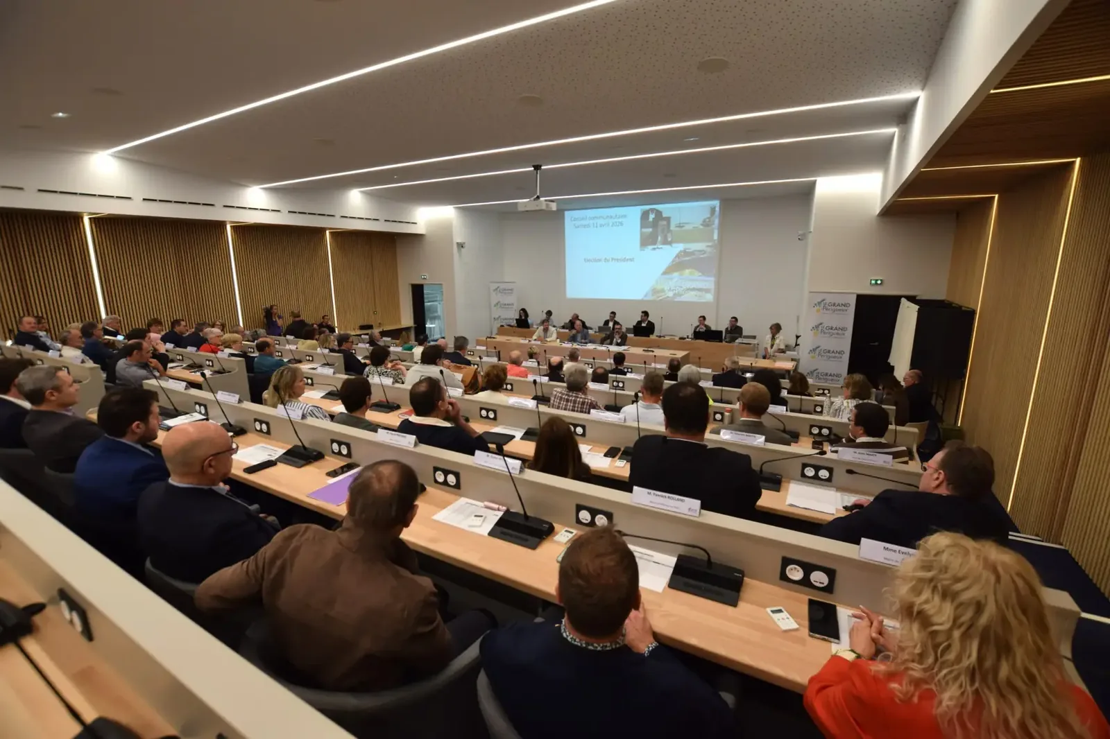 Intermunicipal council meeting, elected representatives seated in tiers in a modern room