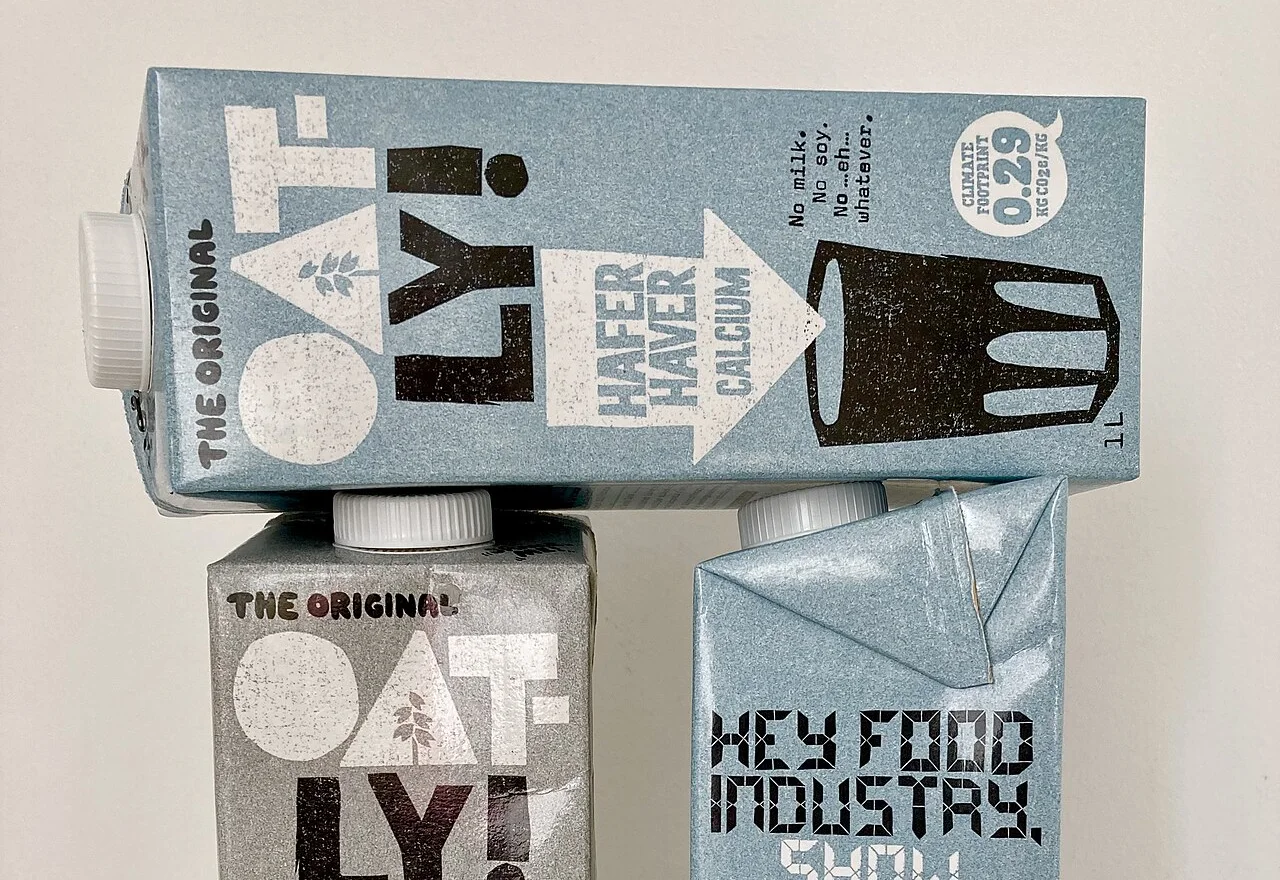 Oatly oat drink cartons, one of which bears a "Climate footprint 0.29 kg CO2e/kg" badge