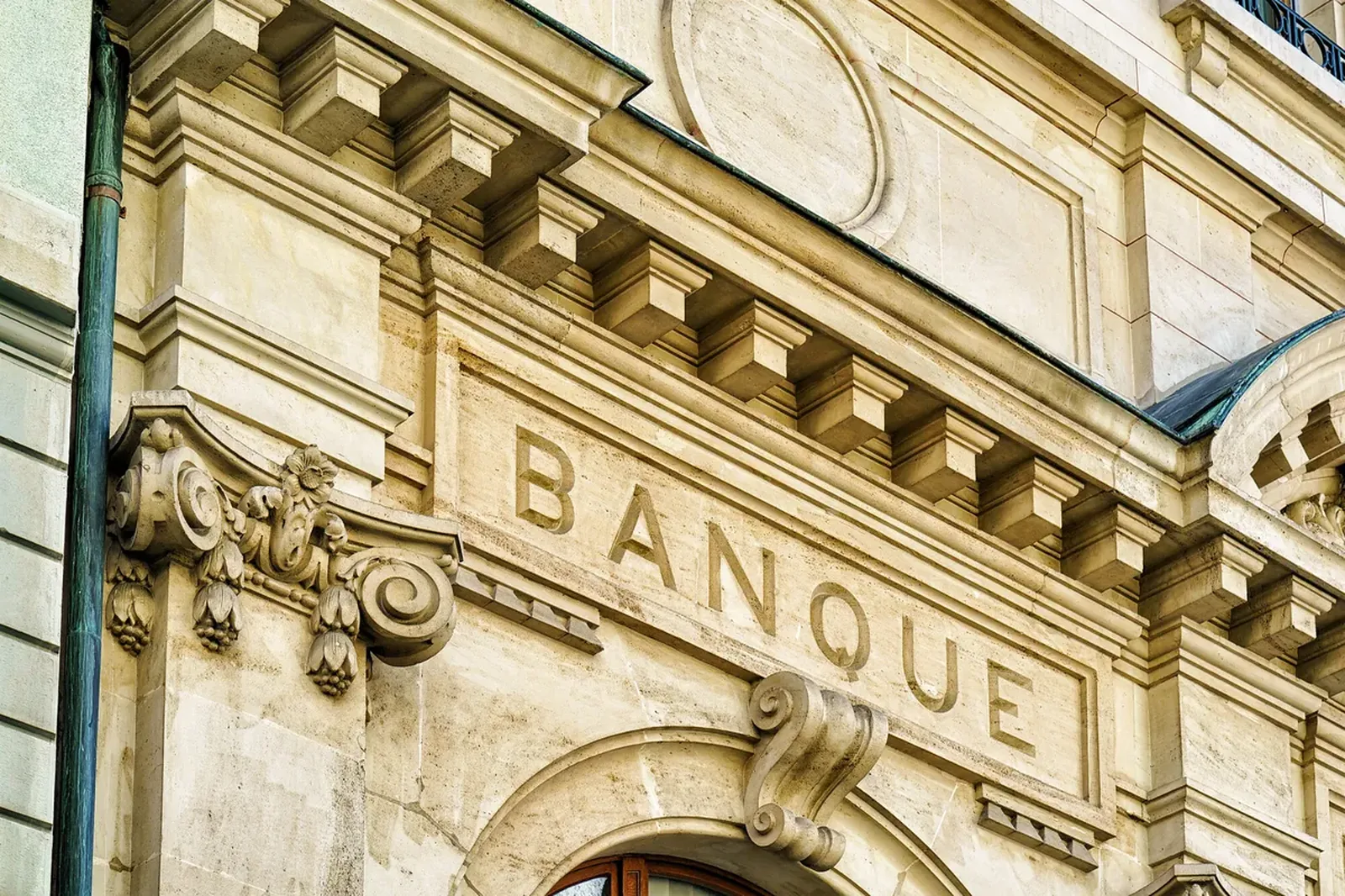 Ashlar stone façade of a traditional bank with the word "BANQUE" carved into the stone