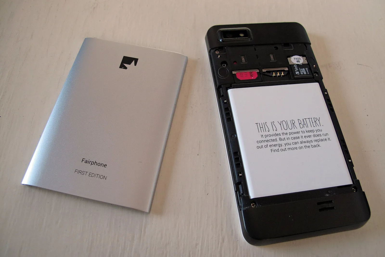 The first Fairphone opened, with the rear cover removed and its removable battery labelled This is your battery