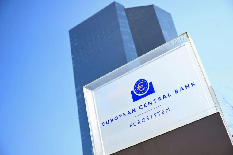 Glass façade of the European Central Bank (Eurotower) in Frankfurt, with its blue European Central Bank Eurosystem sign in the foreground