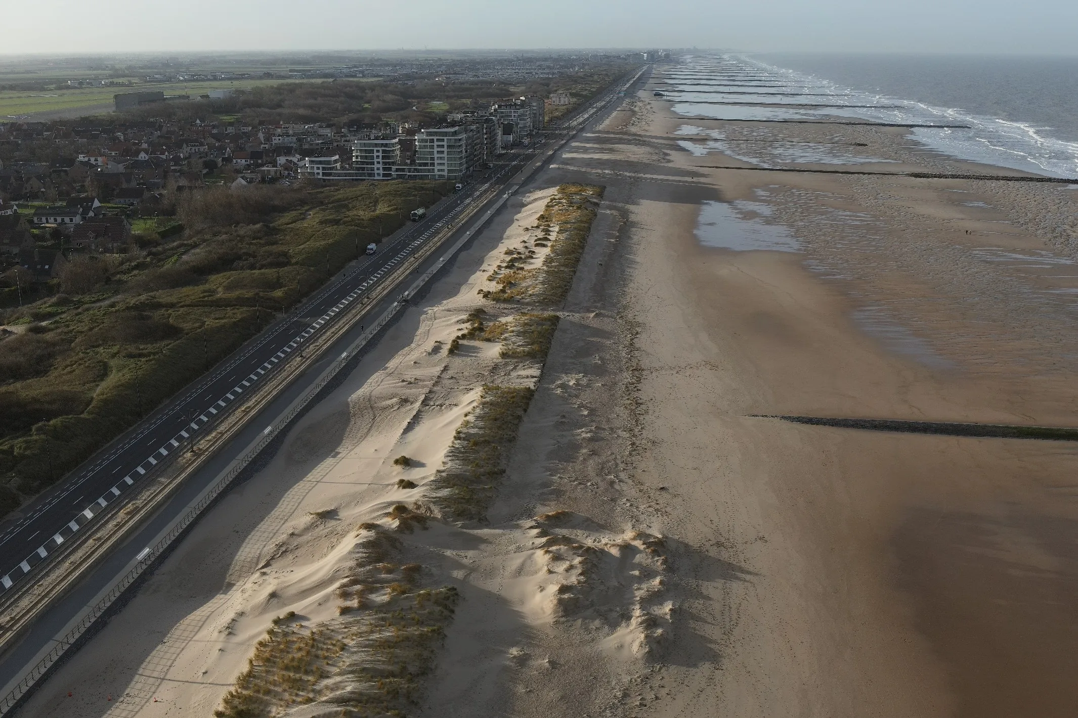 Aerial view of the Belgian coast: dune belt, dyke, built-up seafront and flat polders behind
