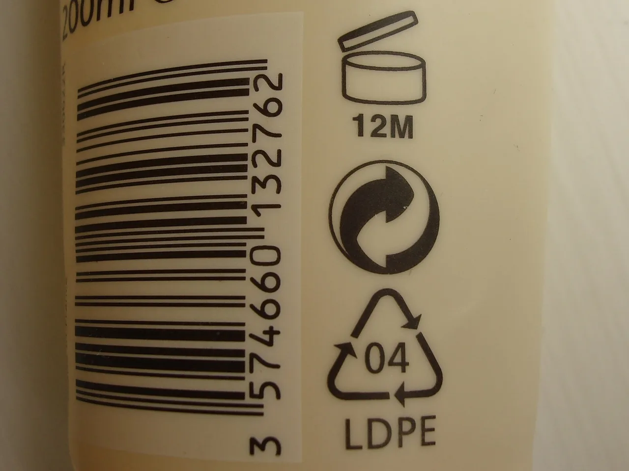 Back of a lotion bottle with a barcode, the open-jar symbol 12M, the Green Dot and the material code 04 LDPE