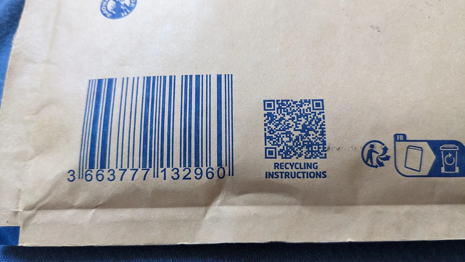 A kraft paper envelope bearing a barcode, a "Recycling instructions" QR code and the Triman logo