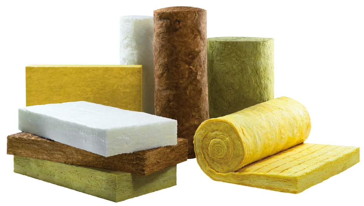 Boards and rolls of yellow glass wool, brown and green stone wool, and white mineral wool, laid side by side on a white background