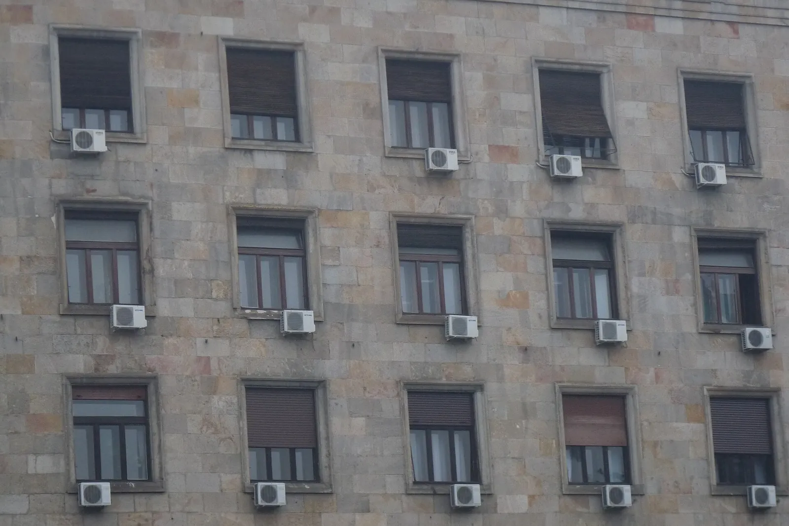 Stone building façade in Belgrade, with an outdoor air-conditioning unit below every window