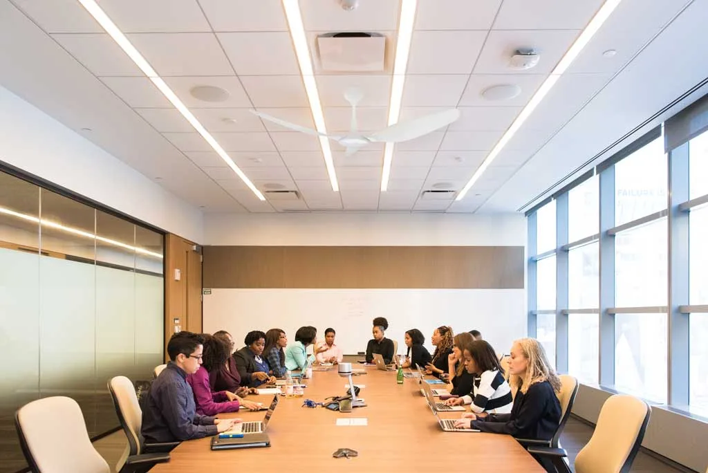 Modern meeting room with a working ceiling fan, occupants comfortable without air conditioning