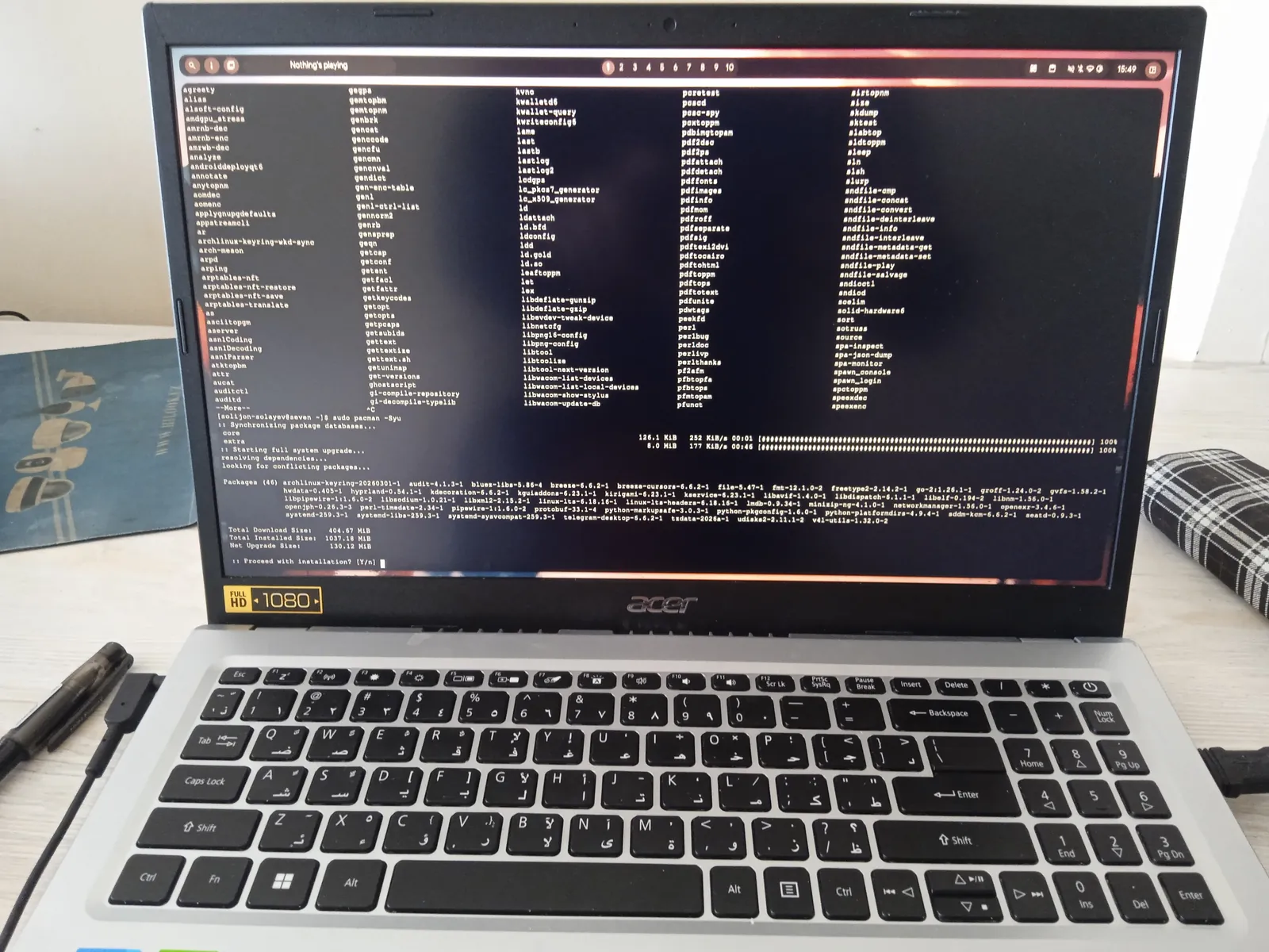 A laptop open, seen close up, its screen showing a terminal full of lines of text