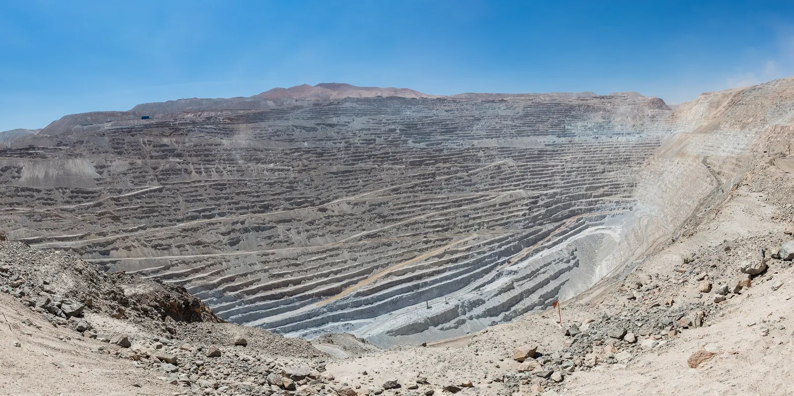Panorama of a huge open-pit copper mine, with its terraced pit in a desert landscape