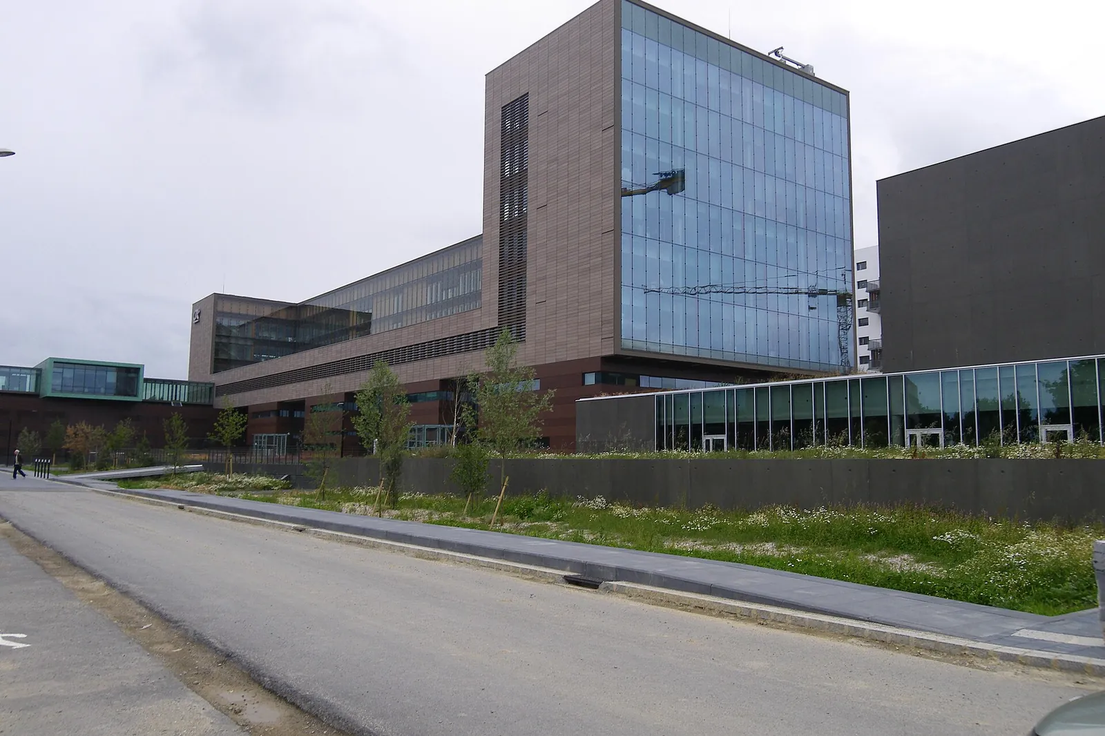 Modern office building with glass façade and brown cladding in a business district under construction in Rennes